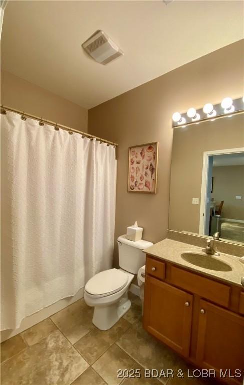 bathroom with vanity, vaulted ceiling, tile patterned floors, and toilet