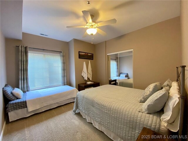 carpeted bedroom with ceiling fan and a closet