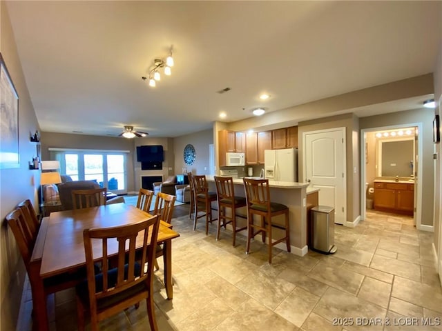 dining room with ceiling fan and sink