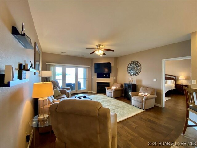 living room with ceiling fan and dark wood-type flooring