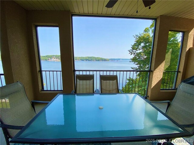 sunroom featuring ceiling fan, a water view, and a wealth of natural light