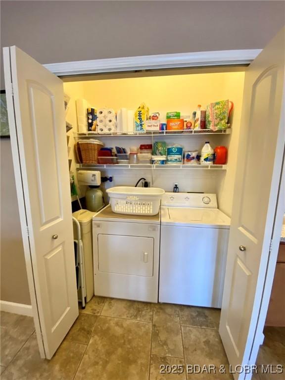 laundry room with tile patterned floors and washer and clothes dryer