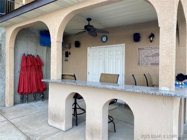 view of patio / terrace with ceiling fan and an outdoor bar