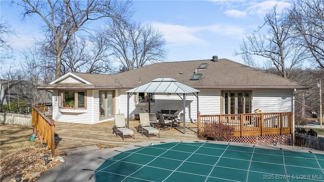 rear view of property with a gazebo and a pool side deck