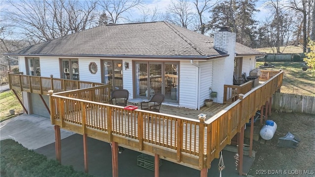 back of property with a garage and a deck