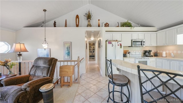 kitchen featuring white appliances, hanging light fixtures, white cabinetry, and tasteful backsplash