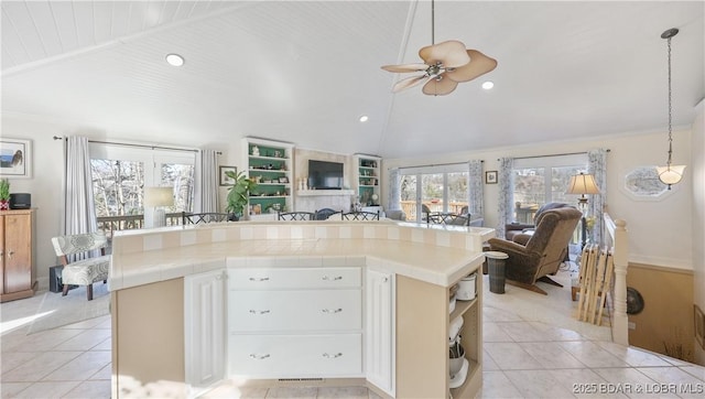 kitchen with a kitchen island, white cabinets, ceiling fan, and light tile patterned floors