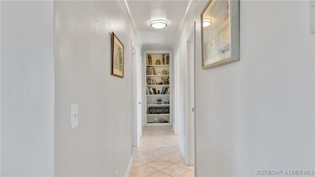 hall with light tile patterned flooring, ornamental molding, and built in shelves