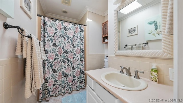 bathroom with ornamental molding, a shower with shower curtain, tile walls, and vanity