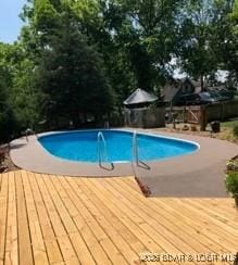 view of pool featuring a patio and a deck