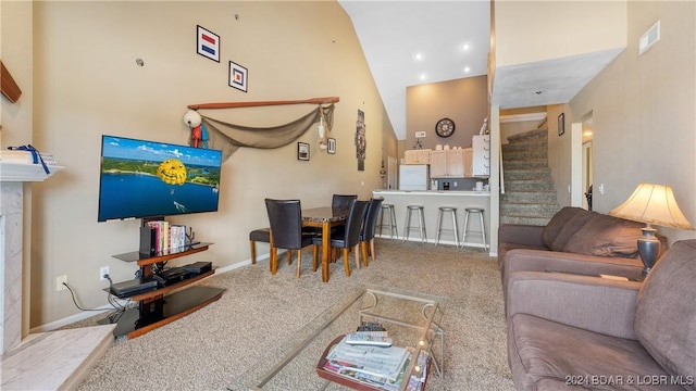 living room with carpet and a towering ceiling