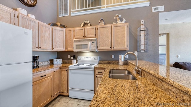 kitchen featuring light stone countertops, sink, light brown cabinets, white appliances, and light tile patterned flooring