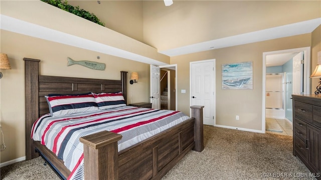 bedroom featuring ensuite bath and light colored carpet