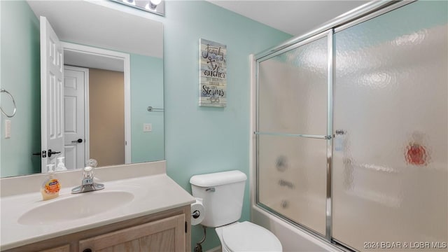 full bathroom with vanity, combined bath / shower with glass door, and toilet