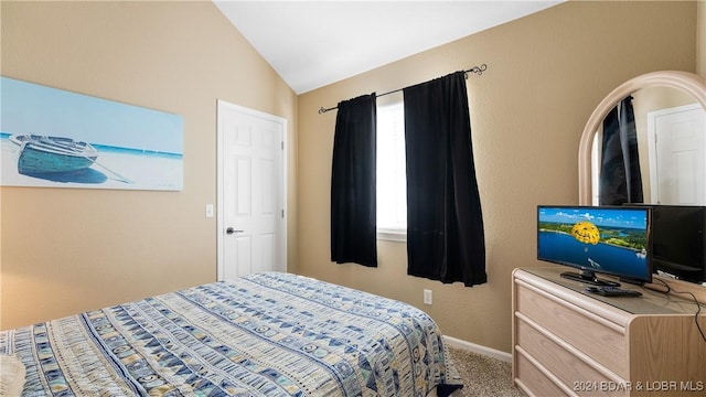 bedroom with carpet floors and vaulted ceiling