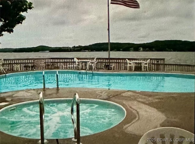 view of swimming pool with a community hot tub