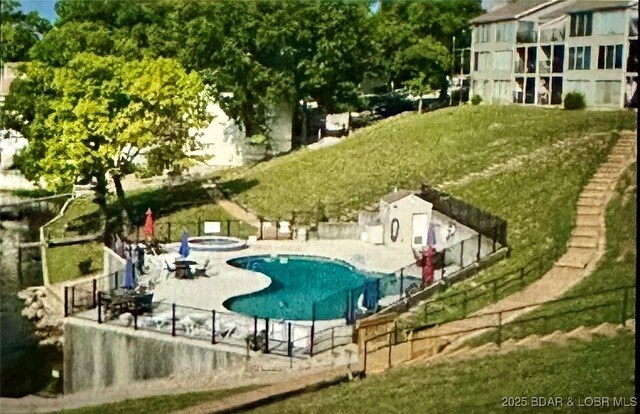 view of swimming pool with an in ground hot tub, a yard, and a patio