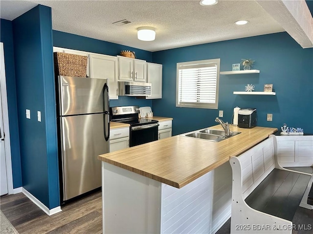 kitchen featuring white cabinets, stainless steel appliances, dark wood-type flooring, and sink