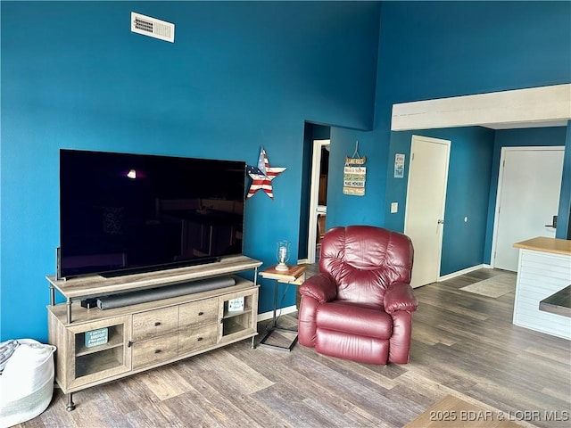 living room with a towering ceiling and hardwood / wood-style floors