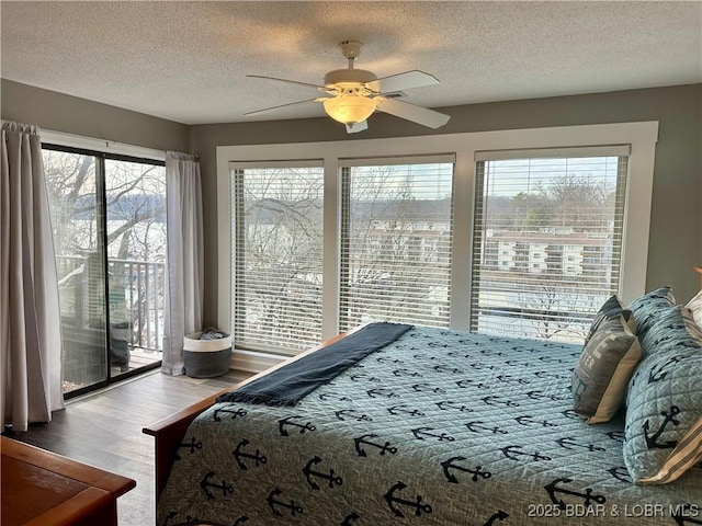 bedroom with access to outside, ceiling fan, wood-type flooring, and a textured ceiling