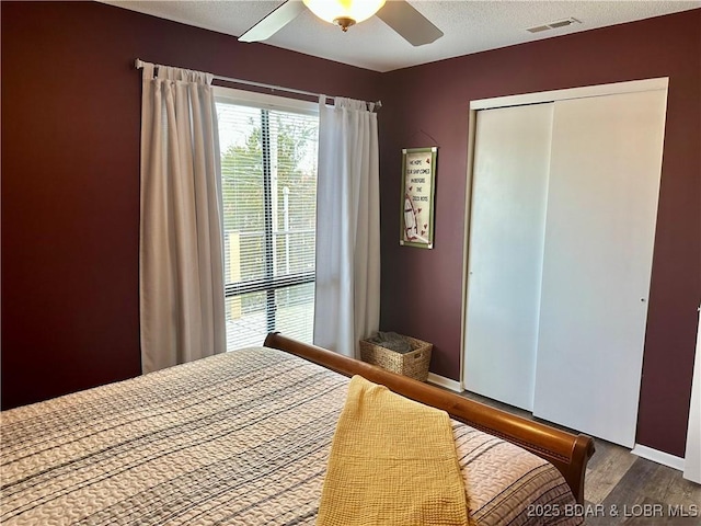 bedroom featuring ceiling fan, a closet, and hardwood / wood-style flooring