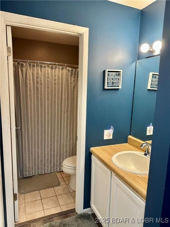 bathroom featuring tile patterned floors, vanity, and toilet