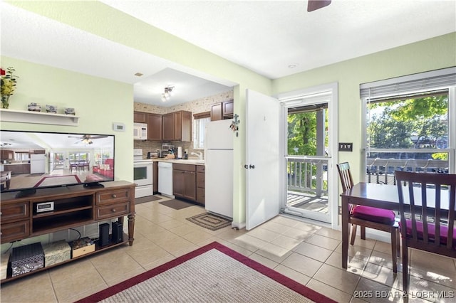 kitchen with white appliances, ceiling fan, light tile patterned floors, and decorative backsplash