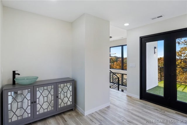 interior space with french doors, light hardwood / wood-style flooring, and sink