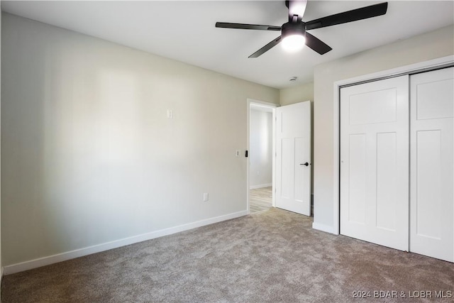 unfurnished bedroom with ceiling fan, a closet, and light colored carpet