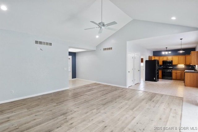 unfurnished living room featuring ceiling fan, light hardwood / wood-style floors, sink, and high vaulted ceiling