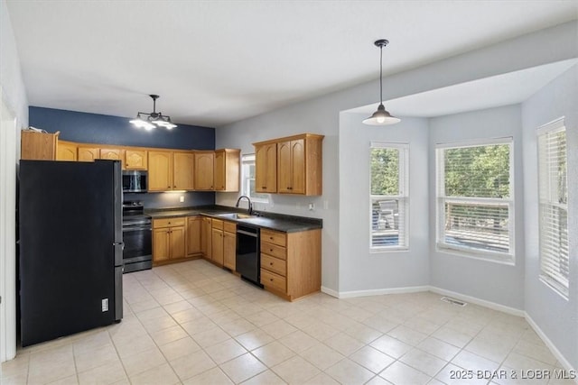 kitchen featuring sink, black appliances, light tile patterned floors, decorative light fixtures, and a chandelier