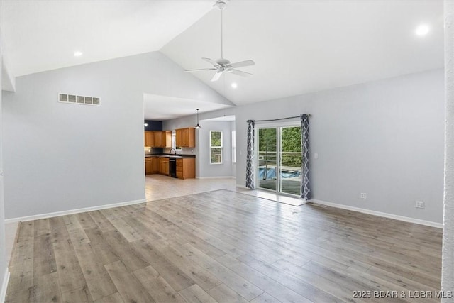 unfurnished living room with light wood-type flooring, high vaulted ceiling, and ceiling fan