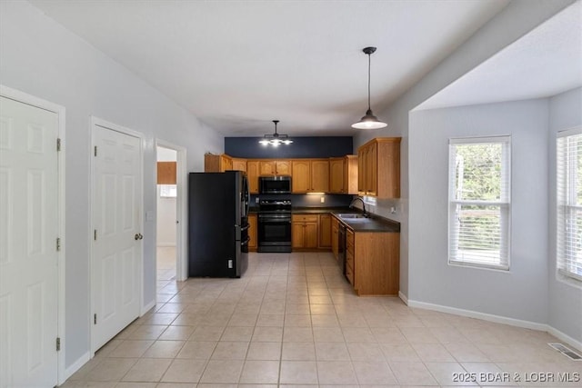 kitchen with light tile patterned flooring, sink, decorative light fixtures, and black appliances