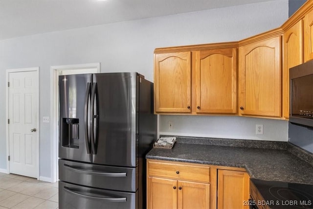 kitchen with stainless steel fridge, light tile patterned floors, and range