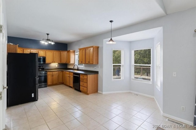 kitchen featuring sink, light tile patterned flooring, black appliances, and decorative light fixtures