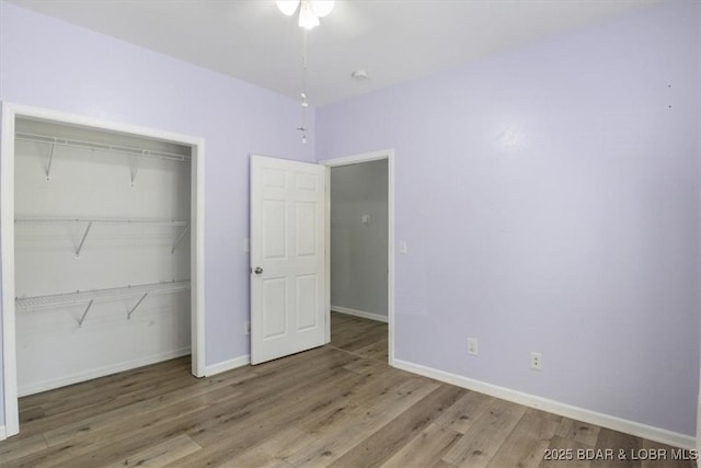 unfurnished bedroom with hardwood / wood-style flooring and a closet