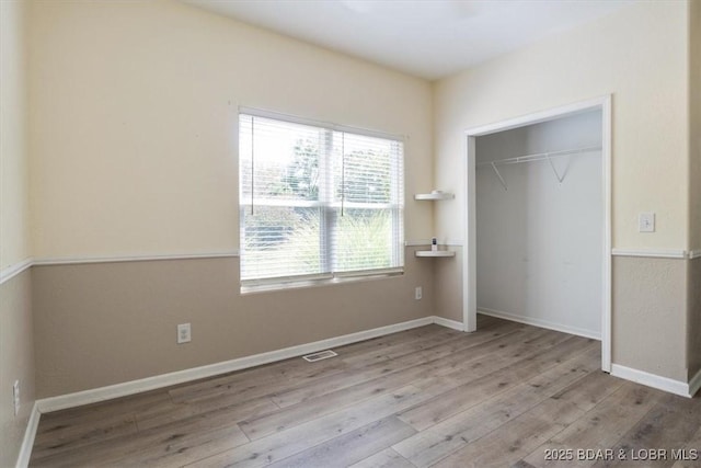 unfurnished bedroom featuring light hardwood / wood-style flooring and a closet