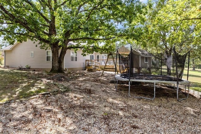 view of yard with a deck and a trampoline