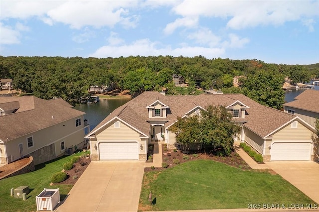 view of front of property with a front yard, a water view, and a garage