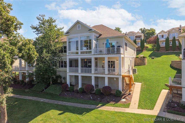 view of front facade featuring central AC unit, a balcony, and a front yard