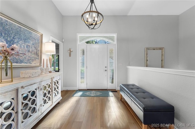 foyer entrance featuring hardwood / wood-style floors and an inviting chandelier