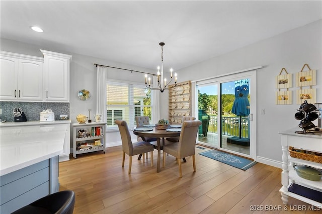 dining space featuring light hardwood / wood-style floors and a notable chandelier