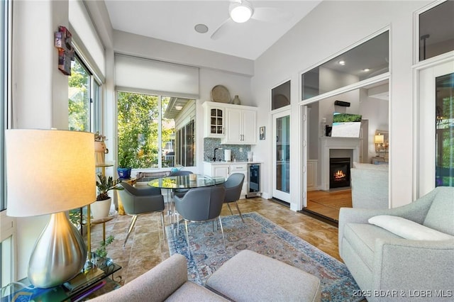 sunroom / solarium with wine cooler, ceiling fan, and sink