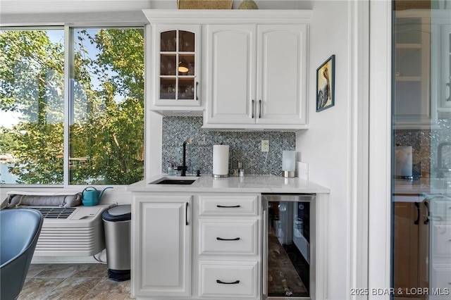 bar featuring backsplash, a healthy amount of sunlight, sink, and wine cooler