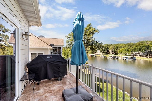 balcony with area for grilling and a water view