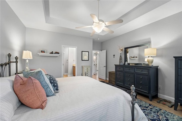 bedroom with connected bathroom, hardwood / wood-style flooring, and ceiling fan