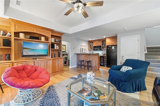 living room with ceiling fan and light wood-type flooring