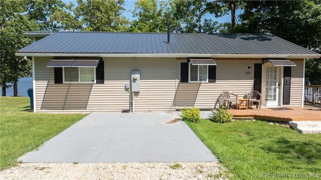 view of front facade with a wooden deck and a front lawn