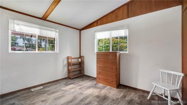 spare room with vaulted ceiling with beams and light wood-type flooring