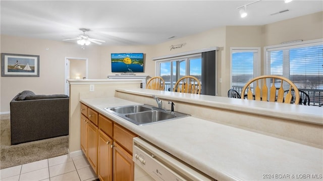 kitchen featuring dishwasher, sink, light tile patterned floors, and ceiling fan